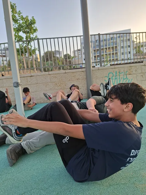 ילדים ונערים באימון קבוצתי על הדשא בפארק