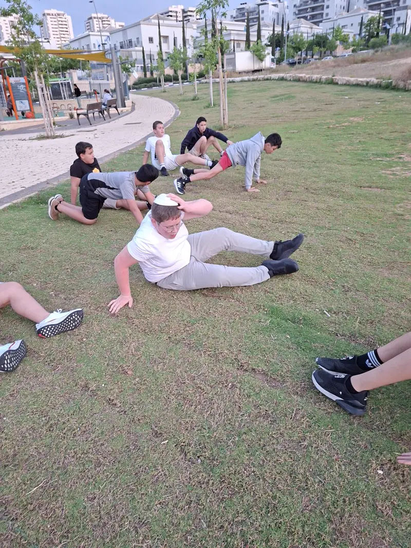 נערים מתאמנים על הדשא בפארק בראש העין
