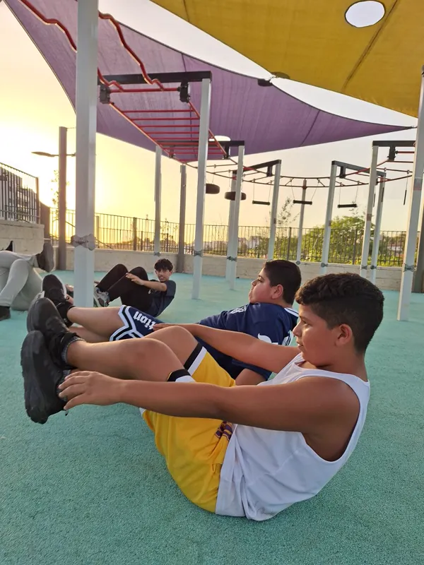מתאמנים במגרש בשעת בין הערביים